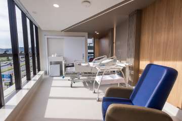 Patient room at Baía Sul Mulher: bed, seating area and equipment, Florianópolis